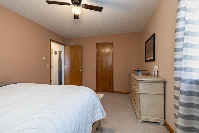 bedroom with a textured ceiling, light colored carpet, and ceiling fan