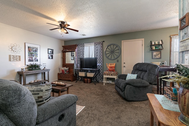 carpeted living room featuring ceiling fan and a textured ceiling