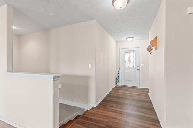 hall featuring a textured ceiling and dark hardwood / wood-style floors