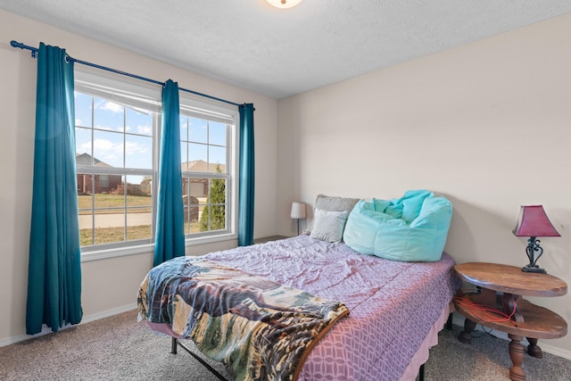 carpeted bedroom featuring a textured ceiling and multiple windows