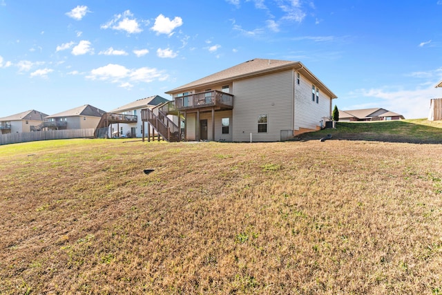 back of house featuring a lawn and a wooden deck