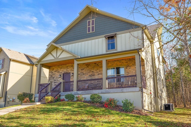 290 Deep Frst Unit 58, Hollister, MO 65672 - view of front of house with covered porch, a front yard, board and batten siding, and stone siding