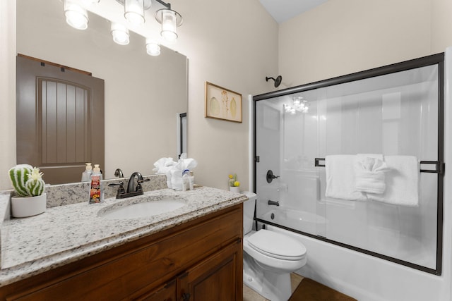 full bathroom with toilet, vanity, and bath / shower combo with glass door