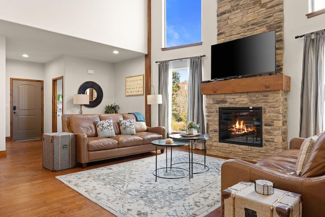 290 Deep Frst Unit 58, Hollister, MO 65672 - living room with a stone fireplace, wood finished floors, recessed lighting, and a high ceiling