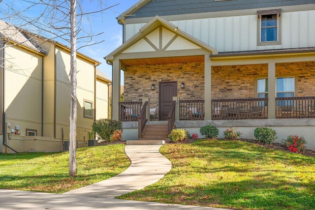 290 Deep Frst Unit 58, Hollister, MO 65672 - view of front of property with a porch, a front lawn, stone siding, and board and batten siding