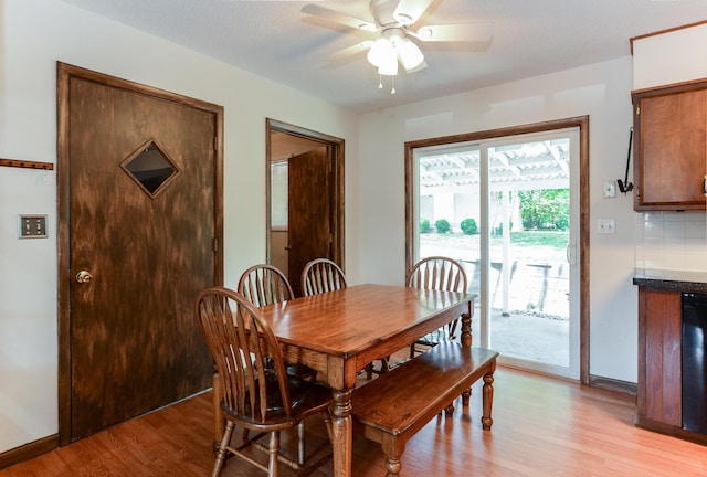 dining area featuring ceiling fan, light hardwood / wood-style flooring, and a textured ceiling