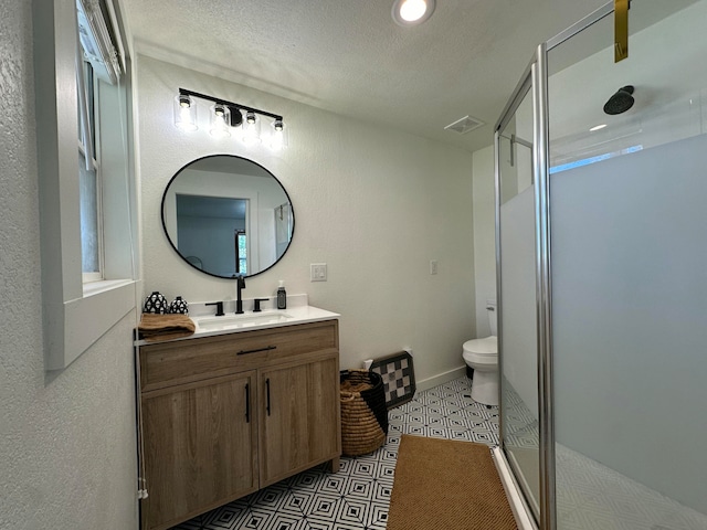 bathroom featuring vanity, toilet, an enclosed shower, and a textured ceiling