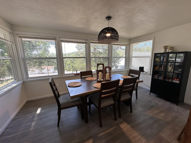 dining area featuring dark hardwood / wood-style flooring, a healthy amount of sunlight, and a textured ceiling