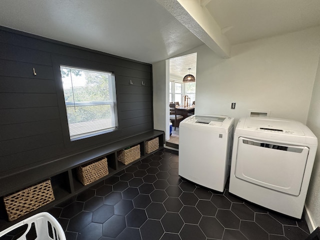 clothes washing area with washer hookup, a textured ceiling, and dark tile patterned flooring