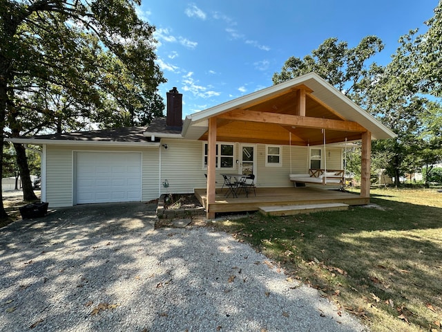 view of front of house with a wooden deck, a front lawn, and a garage