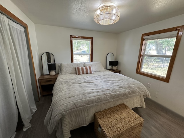 bedroom with a textured ceiling and dark hardwood / wood-style flooring