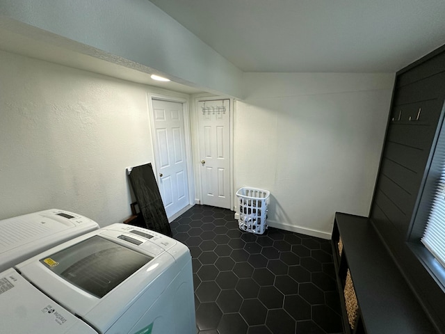 laundry room with washing machine and dryer and dark tile patterned flooring