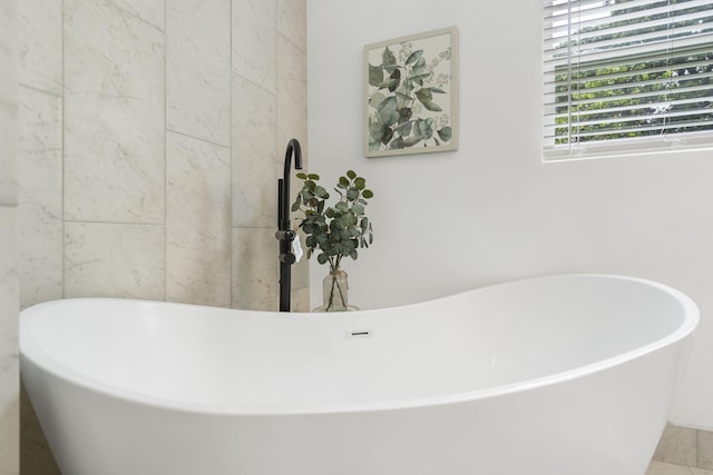 bathroom featuring tile patterned flooring and a tub to relax in