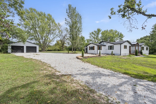 exterior space with a front yard, an outbuilding, and a garage