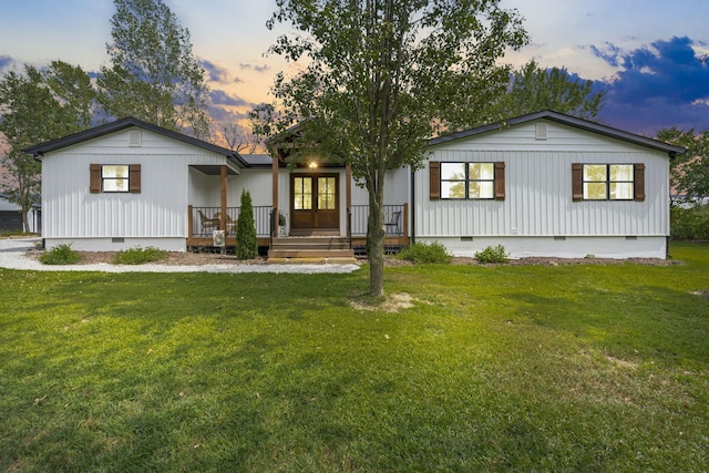 view of front of home featuring a yard, french doors, and a porch