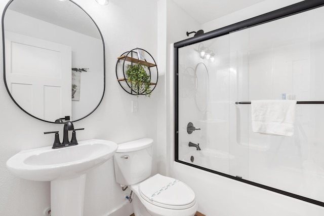 full bathroom featuring sink, enclosed tub / shower combo, and toilet