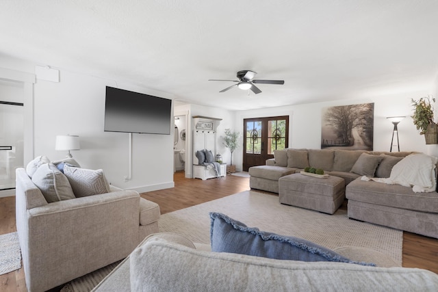 living room featuring wood-type flooring, french doors, and ceiling fan