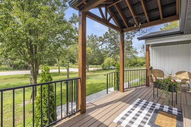 wooden terrace featuring a lawn