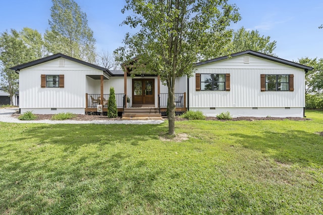 view of front of property featuring a porch, a front yard, and french doors