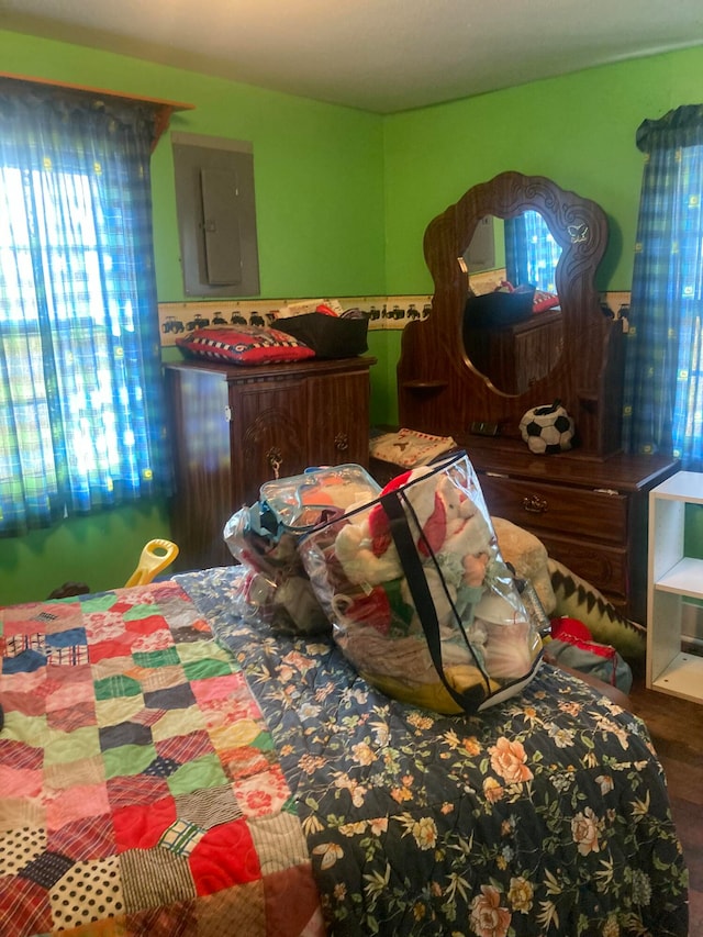 bedroom featuring hardwood / wood-style floors and electric panel