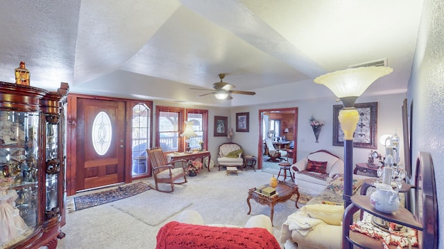 living room with ceiling fan, carpet floors, a textured ceiling, and vaulted ceiling