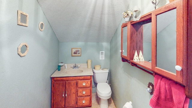 bathroom with tile patterned flooring, a textured ceiling, vaulted ceiling, toilet, and vanity