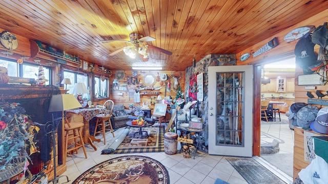 interior space featuring ceiling fan, light tile patterned flooring, and wood ceiling