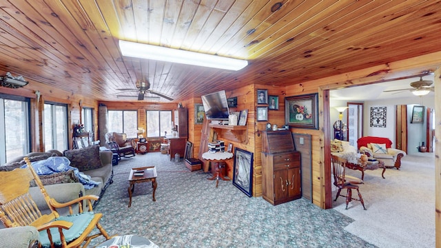 living room with ceiling fan, wooden walls, carpet, and wood ceiling