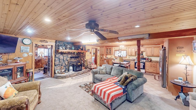 carpeted living room with a wood stove, ceiling fan, and wooden ceiling