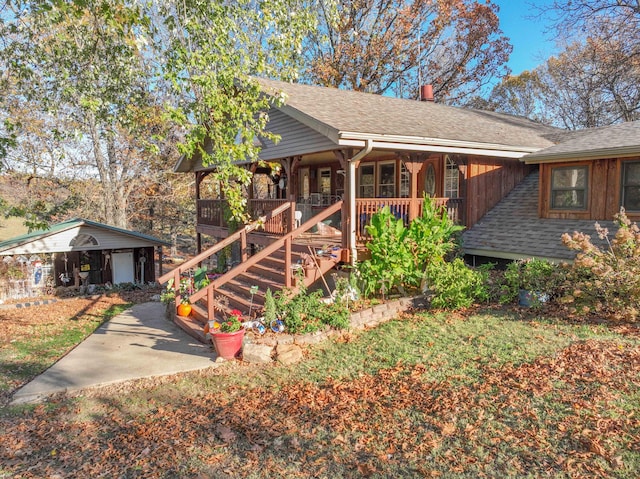 view of front of property with an outdoor structure, a porch, and a garage