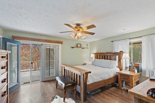 bedroom with a textured ceiling, access to outside, dark hardwood / wood-style floors, and ceiling fan