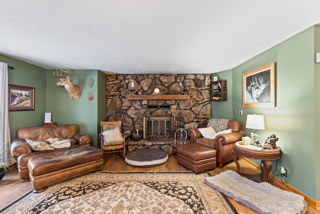 living room featuring hardwood / wood-style flooring and a stone fireplace