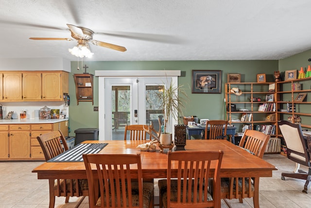 dining area featuring ceiling fan, light tile patterned flooring, a textured ceiling, and french doors