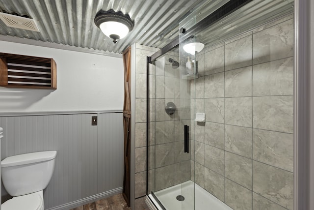 bathroom with walk in shower, wood-type flooring, and toilet