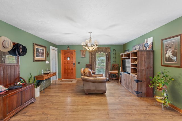 living room with light hardwood / wood-style floors and an inviting chandelier