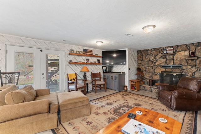 living room featuring wood walls, a textured ceiling, and hardwood / wood-style flooring