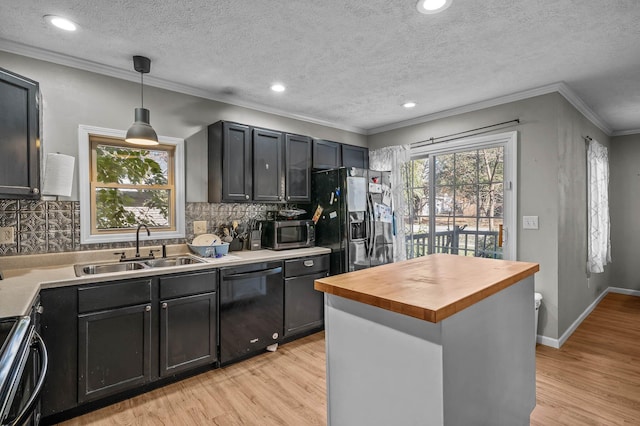 kitchen with black appliances, light wood-type flooring, sink, and hanging light fixtures