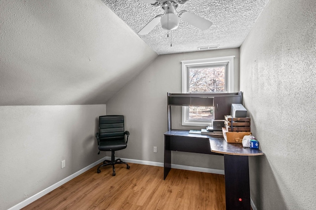 office space featuring hardwood / wood-style flooring, ceiling fan, a textured ceiling, and vaulted ceiling