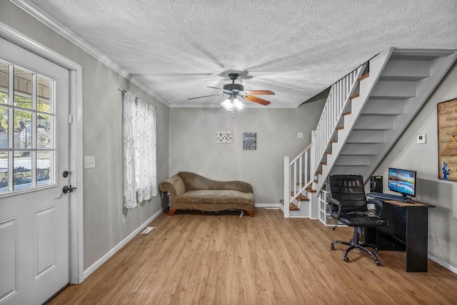 office featuring a textured ceiling, light hardwood / wood-style floors, ceiling fan, and ornamental molding