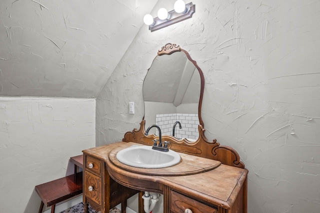 bathroom with vanity and lofted ceiling