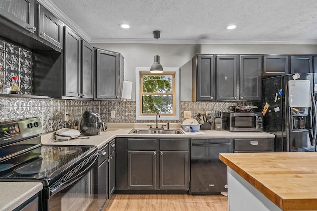 kitchen with pendant lighting, black appliances, crown molding, sink, and a textured ceiling