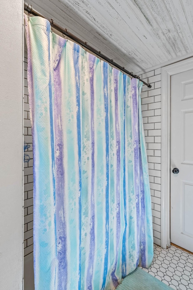 bathroom featuring walk in shower and wood ceiling