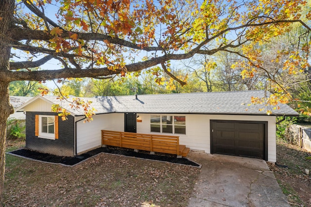 ranch-style house featuring a wooden deck and a garage