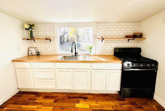 kitchen with sink, black gas range oven, dark hardwood / wood-style floors, butcher block countertops, and backsplash