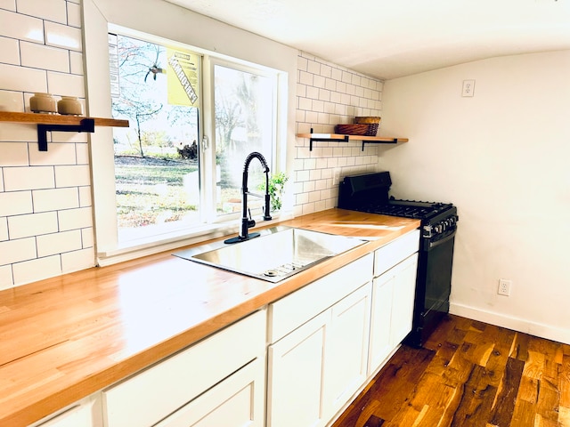 kitchen featuring black gas stove, butcher block countertops, plenty of natural light, and sink