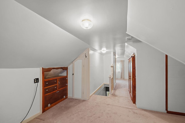 bonus room with light colored carpet and lofted ceiling