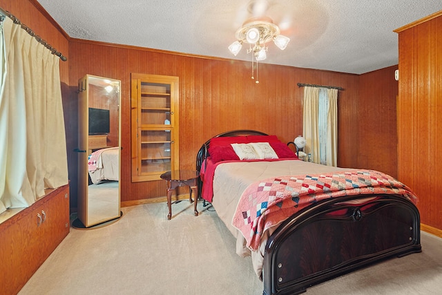 bedroom featuring ceiling fan, a textured ceiling, and wooden walls