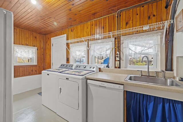 laundry room with separate washer and dryer, wooden ceiling, wooden walls, and sink