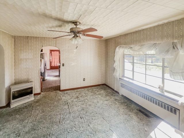 carpeted spare room with ceiling fan, radiator heating unit, and heating unit