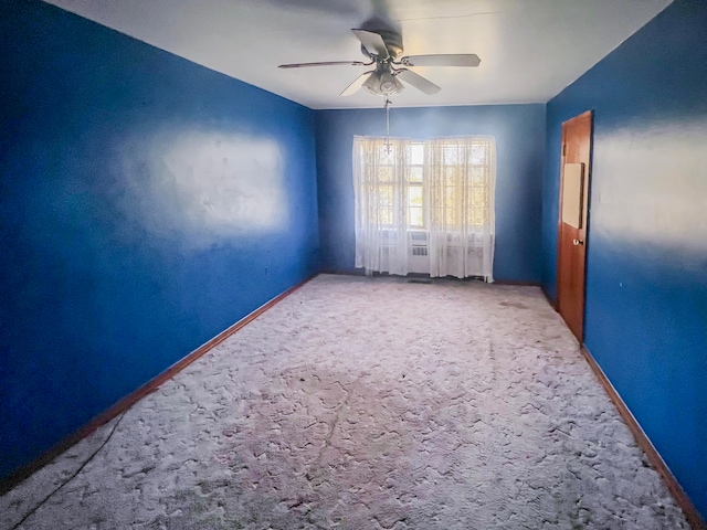 unfurnished room with ceiling fan and carpet